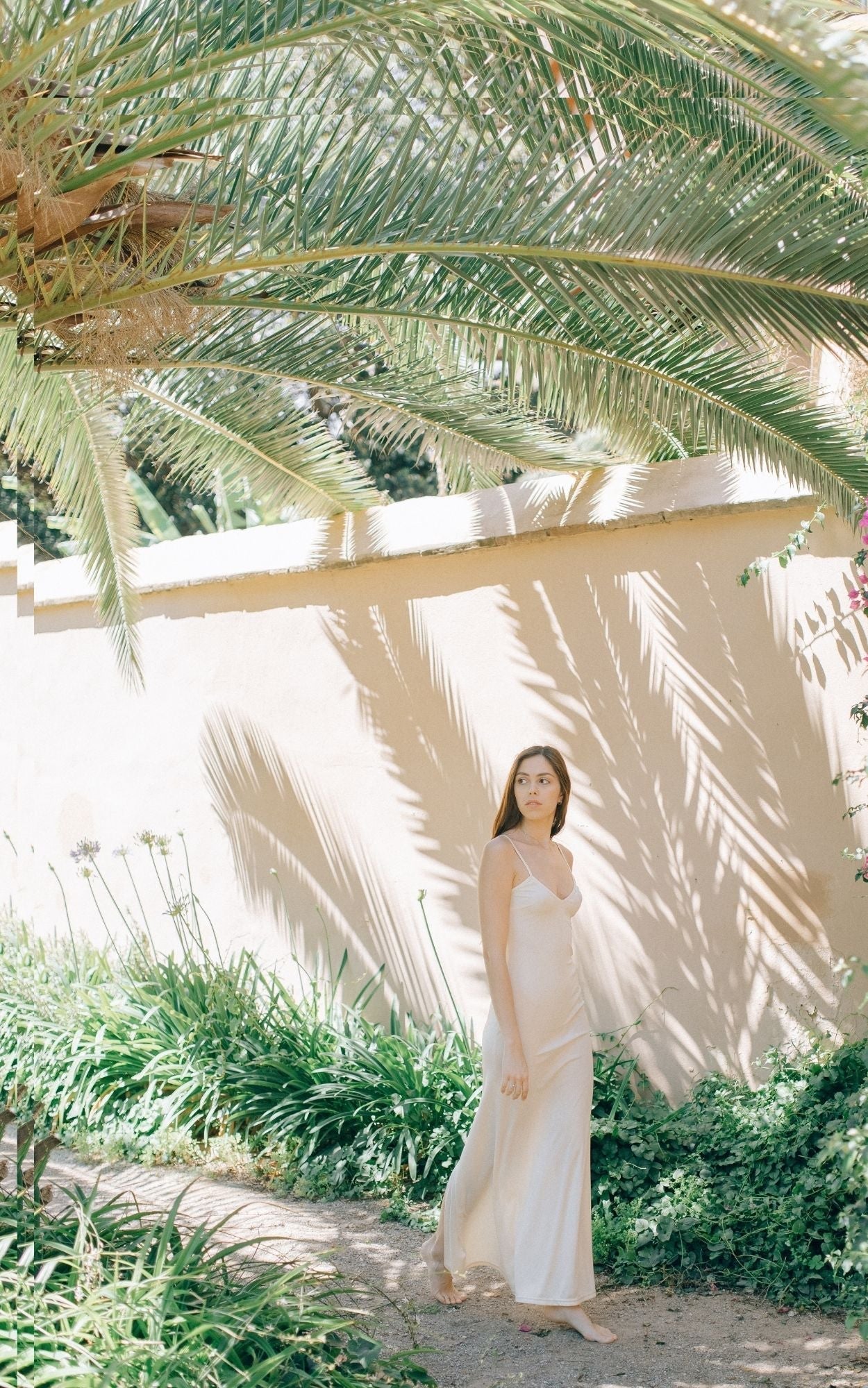 Woman in a peaceful garden wearing Pearl Limited Edition Shimmering 1/4 oz Gemstone Perfume Oil Concentrate Roll on